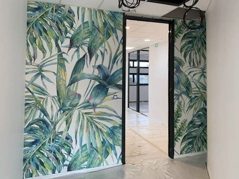 Chantier de rénovation intérieure en cours avec ouvriers installant cloisons et revêtements muraux