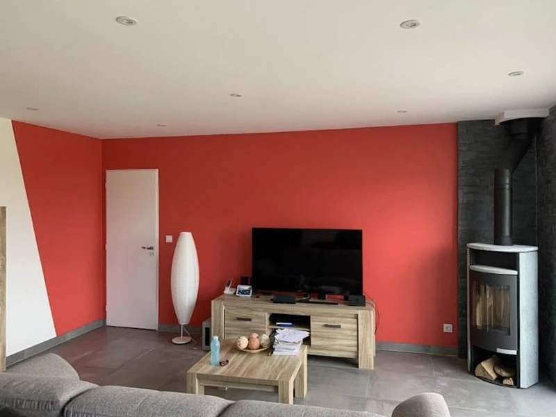 Salon moderne avec mur d'accent rouge vif, sol carrelage gris anthracite