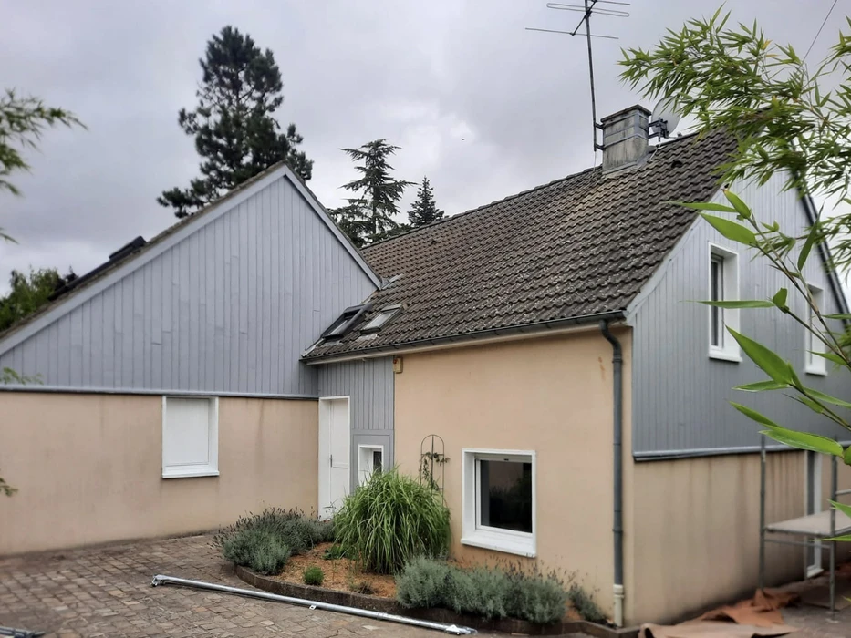 Façade extérieure d'une maison individuelle récemment rénovée avec enduit beige clair