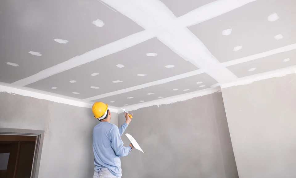 Le mur sec de plâtrage est prêt à être peint dans une nouvelle maison en construction