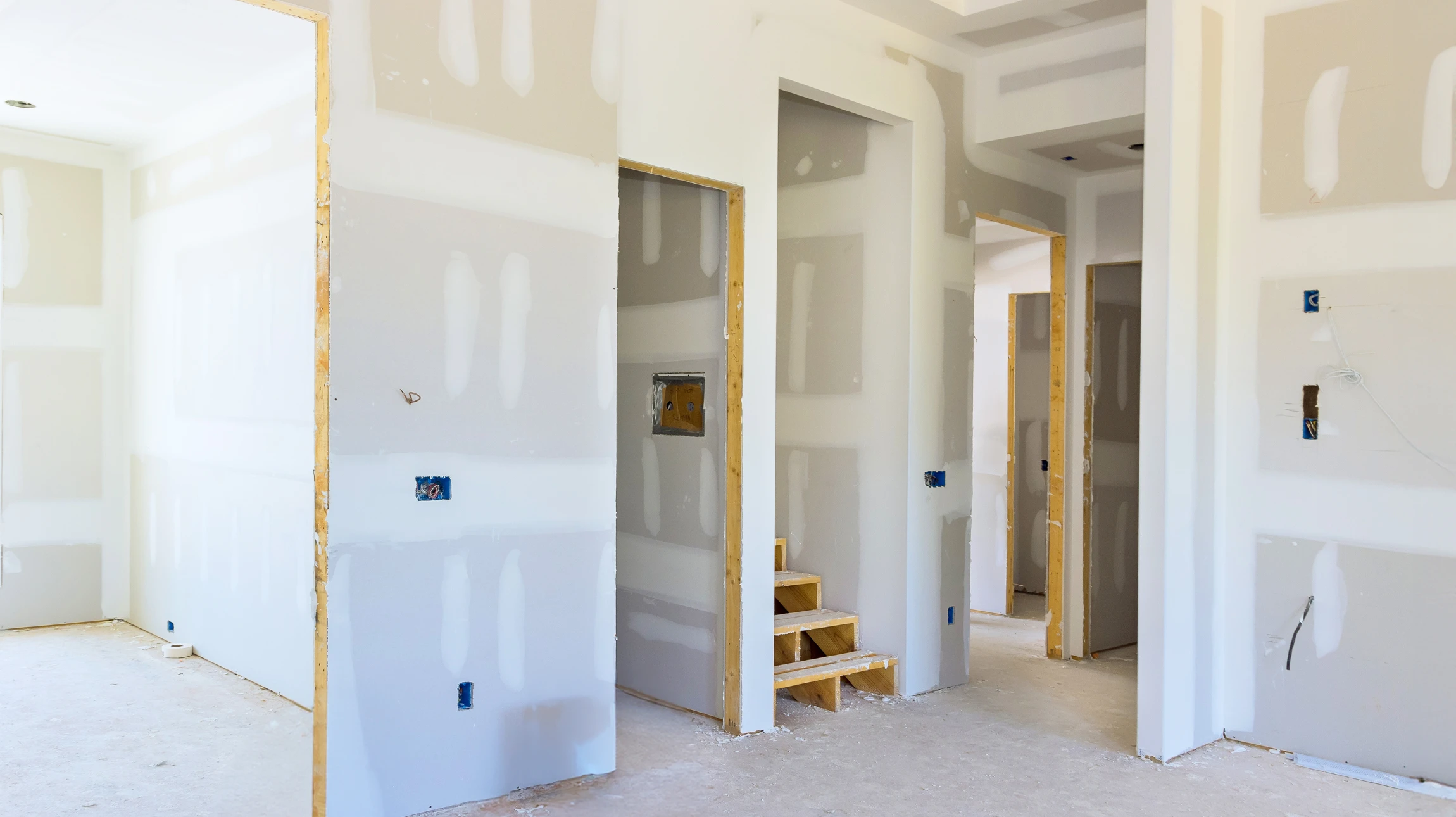 Ouvrier en bâtiment installant des cloisons sèches dans un intérieur en rénovation