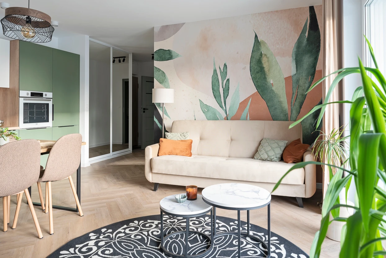 Salon moderne avec canapé gris à capitons sur pieds en bois, mur orange vif, porte blanche à panneaux