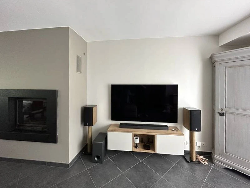Intérieur d'appartement en rénovation avec mur accent bleu-vert, parquet sombre et murs blancs