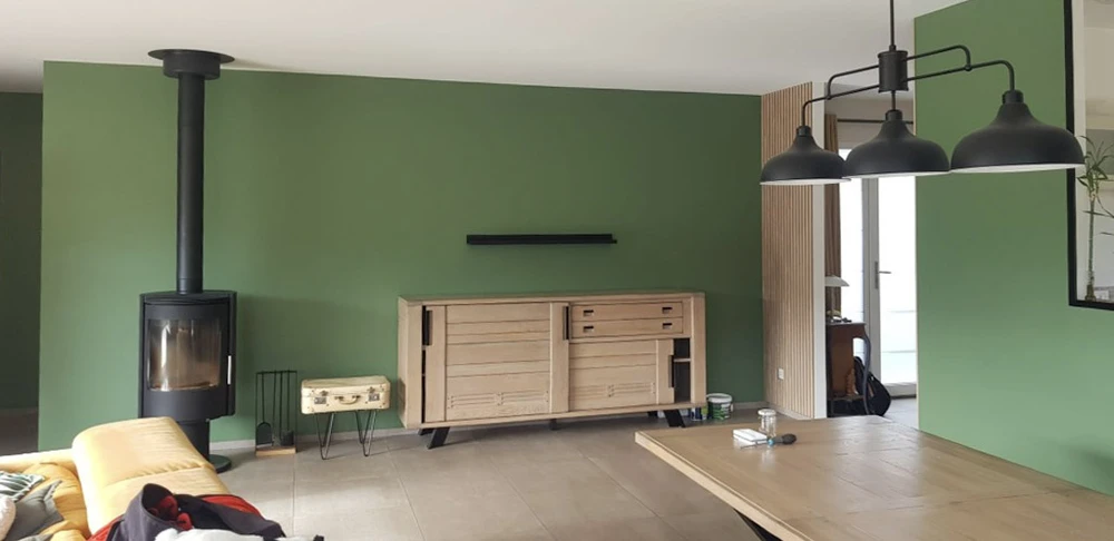 Intérieur en cours de rénovation avec mur accent bleu marine, parquet bois naturel nouvellement posé