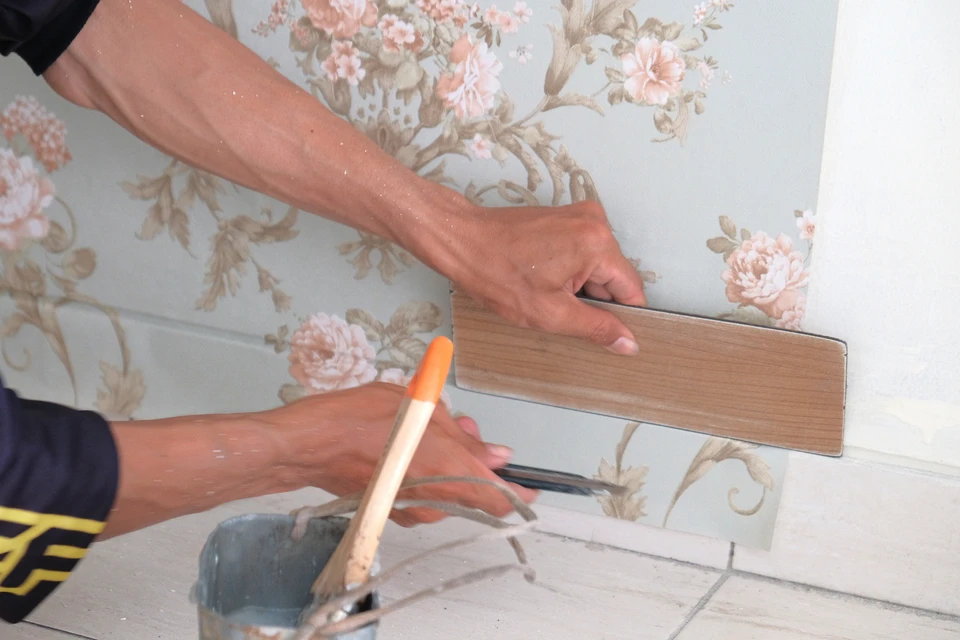 Artiste barbu adulte concentré avec papier à la main vérifiant les informations sur l'ordinateur portable pendant son travail dans un atelier de menuiserie