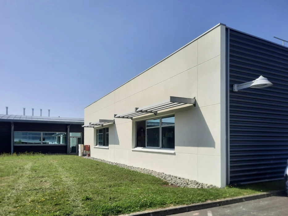 Maison individuelle contemporaine à étage avec façade blanche, volets rouges et toiture en ardoise